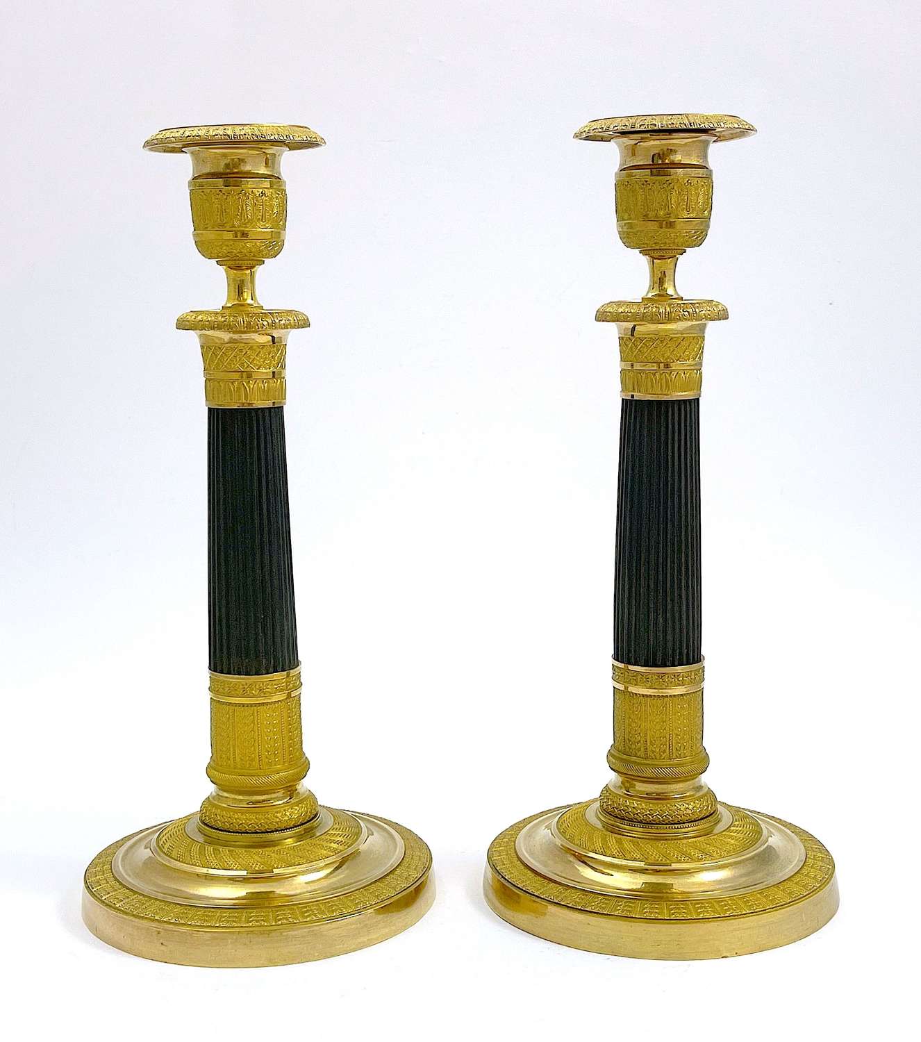 A Fine Pair of French Empire Parcel Gilt and Bronze Candlesticks